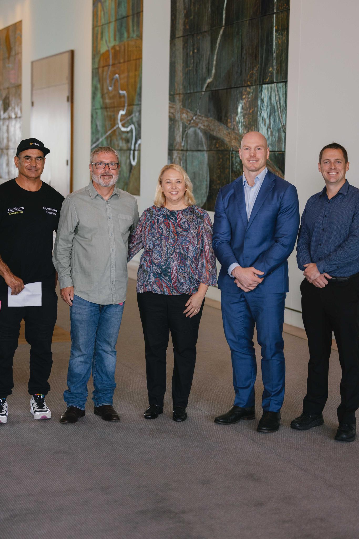 Five people stand for a group photo. Left to right: Ritchie Allen, Bradley Bell, Dr. Siwan Lovett, Sen. David Pocock, Andy Lowes.