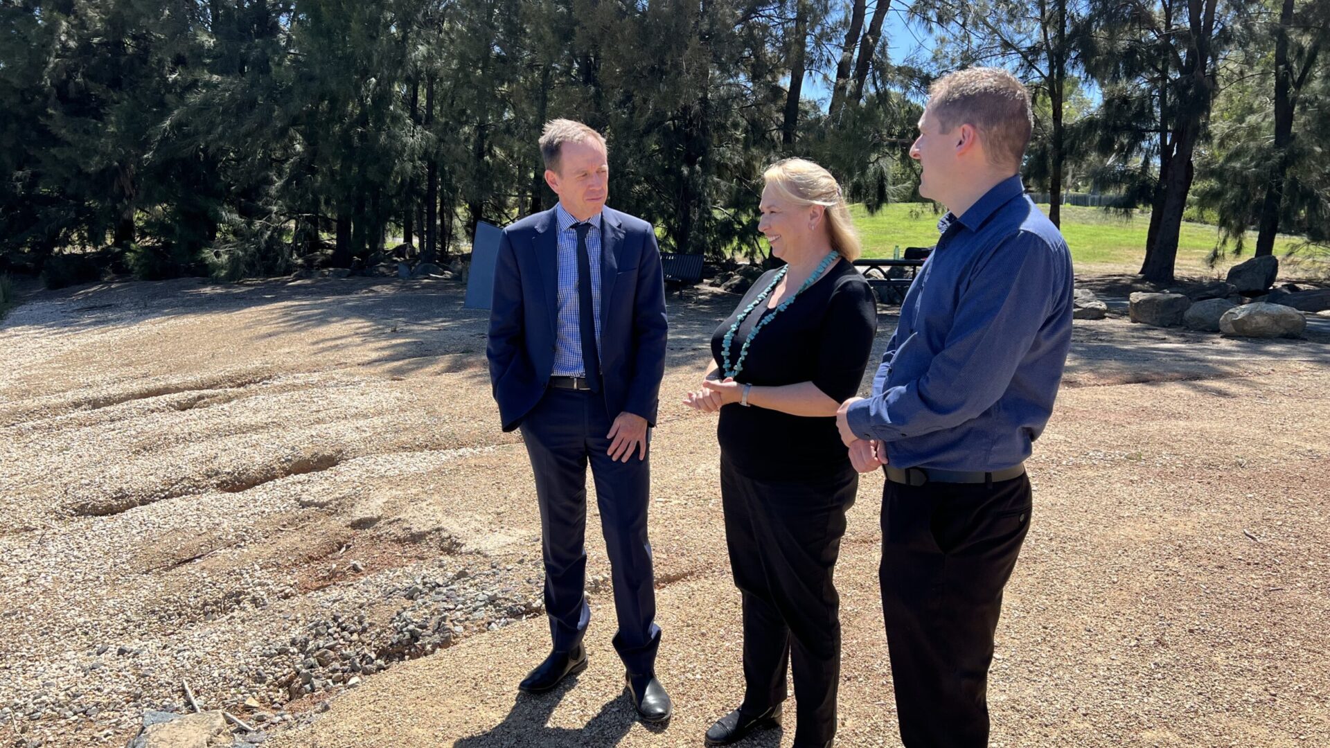 Shane Rattenbury MLA, Dr. Siwan Lovett and Andy Lowes stand on the banks of Lake Burley Griffin.